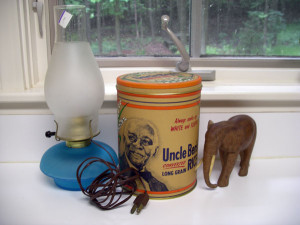 ビンテージっぽいテーブルランプとブリキ缶容器、それと木彫りの象さんの置物。